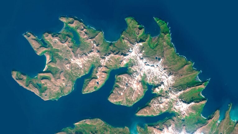 Satellite view of Iceland highlighting volcanic regions and glaciers.