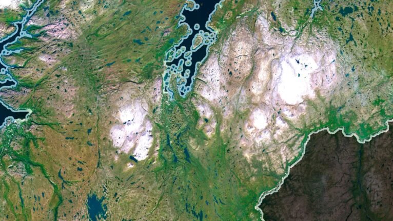 Satellite view of Norway highlighting the fjords and mountain ranges.